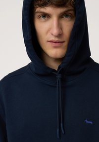 Sudadera azul marino hecha de una suave mezcla de algodón, con cordón, bolsillo canguro y pequeño logo de perro bordado en púrpura.
