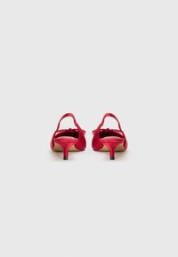 Røde satin hælede sandaler med en lille hæl, ankelstropper og sløjfe accenter bagpå. Glat tekstur og klassisk design.
