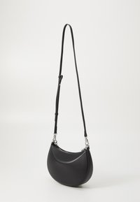 Bolso de hombro de cuero negro con forma curva, correa ajustable y herrajes plateados. Textura suave con un diseño minimalista.