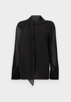 Mustast särgist, millel on sile, läbipaistev kangas. Omaduseks on drapeeritud krae ja pikad varrukad nööbitavate mansettidega. Serv on ees terav.