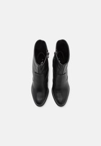 Black leather ankle boots with a pointed toe, smooth finish, side zipper closure, and a minimalistic design. Size marked as 37 inside.
