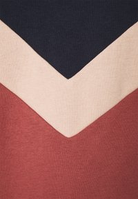 Pull en tricot avec un motif en chevrons dans des couleurs marine, beige et rouille ; texture douce ; tissu décontracté, idéal pour le superposition.