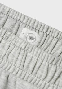 Szara bawełniana talia z marszczoną fakturą i plastikowym zapięciem na guzik, z miękką powierzchnią materiału i minimalnym detalem szwów.