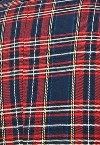 Tessuto tartan rosso e blu con linee bianche, gialle e blu che si incrociano, caratterizzato da un'intrecciatura testurizzata e un classico motivo a quadri.