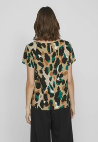 Top a maniche corte con sfondo beige, caratterizzato da un motivo a stampa leopardata in nero, marrone, verde e dettagli bianchi. Dettaglio a chiave sulla parte posteriore.