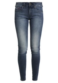 Úzké džíny z denimu v tmavě modré barvě, s mírně vybledlým vzhledem, pěticí kapsami a kovovým zapínáním. Diskrétní šití na kapsách.