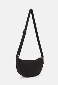 Svart axelväska av mjukt tyg, med en rundad form och justerbar rem. Dragkedjestängning med en minimalistisk design.