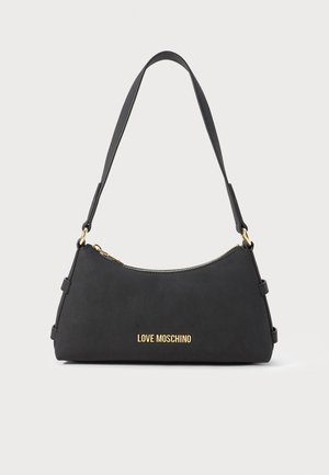 Must nagu Moschino õlakott musta värvi, kullatud tõmbluku ja logoga, struktureeritud kuju ning üks lai rihm, valge tausta ees.