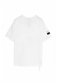 Camiseta blanca de manga corta con cuello redondo, que presenta un detalle de etiqueta en blanco y negro en la manga izquierda y un diseño de corte recto.