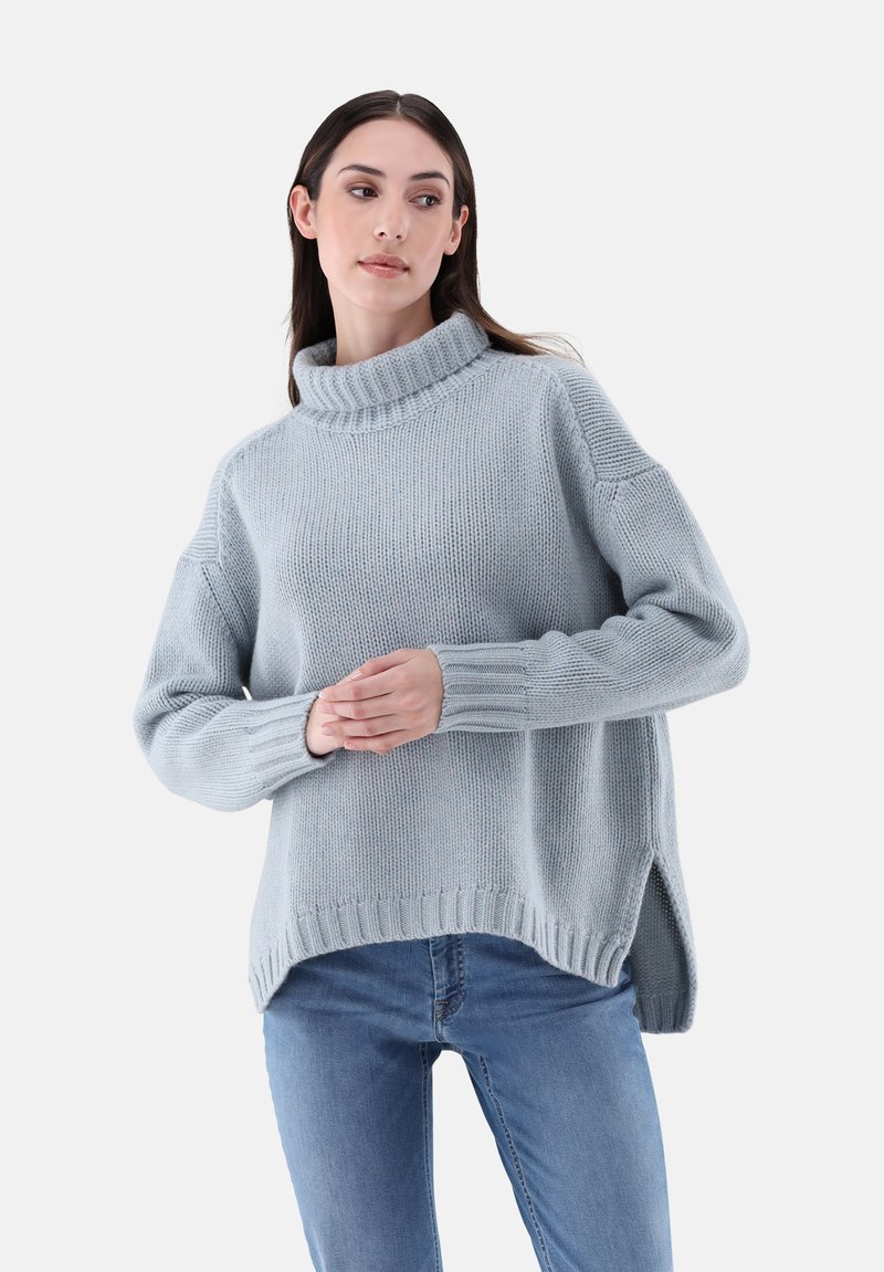 Helles blaues Strickpullover mit einem hohen, gerippten Kragen, überschnittenen Schultern und Seitenschlitzen am Saum. Der Stoff ist strukturiert und weich.
