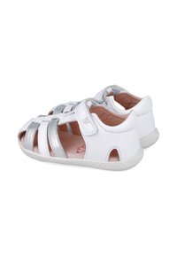 Sandalias de cuero blanco con acentos plateados, diseño de punta abierta y correa de Velcro. Presentan un suave forro interior y una suela texturizada para mayor agarre.