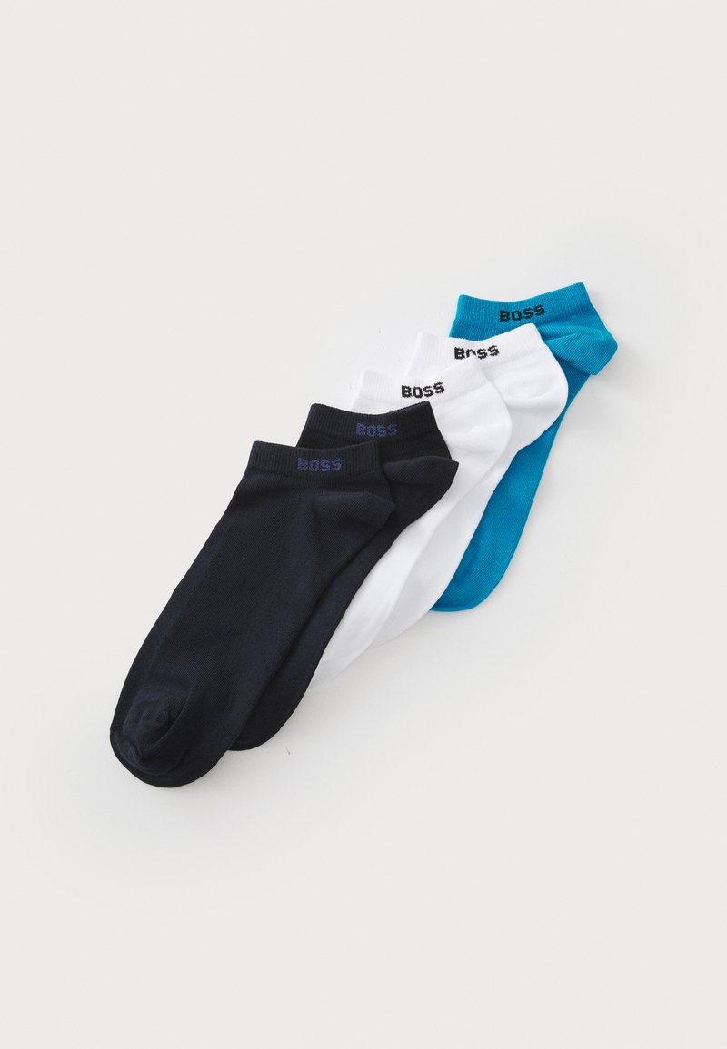 Vier Paar kurze Socken in Schwarz, Weiß und Teal. Aus weichem Stoff mit gerippter Textur gefertigt. Jedes Paar zeigt das 'BOSS'-Logo an dem Bündchen.