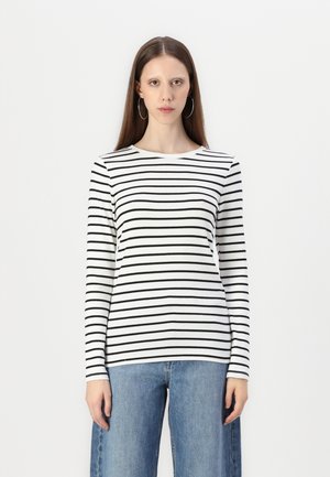 Long-sleeve shirt with black and white horizontal stripes, round neckline, soft fabric, paired with light blue wide-leg jeans.