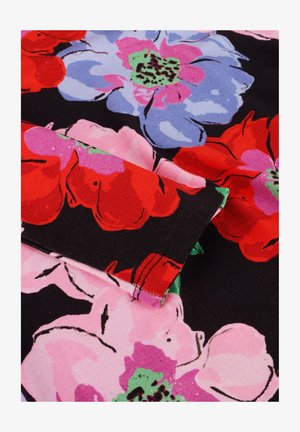 Close-up van stof met een groot bloemenpatroon in rood, roze, paars en groen op een zwarte achtergrond, met zichtbare stikdetails.