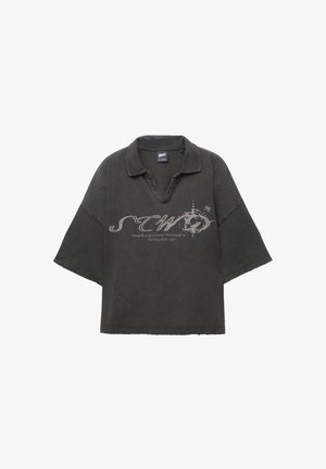 Oversized zwarte poloshirt met een kraag, korte mouwen en een verouderde textuur. Heeft een grafische print in lichtgrijs aan de voorkant.