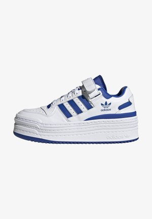 Biała i niebieska niska sneaker z platformą Adidas z grubą podeszwą, trzema niebieskimi paskami, sznurowaniem z przodu i paskiem na rzep nad sznurowadłami.