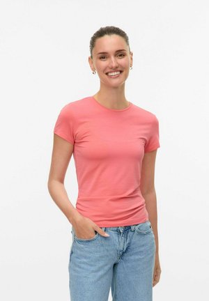 Lyserød kortærmet t-shirt lavet af blødt stof, med rund halsudskæring og tætsiddende design, båret med lyseblå jeans.