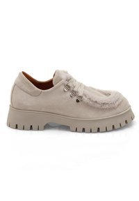 Chaussure en daim beige avec une semelle en caoutchouc épaisse, dotée de détails en peluche et de œillets en métal pour les lacets, forme de orteil arrondie et variation texturale.