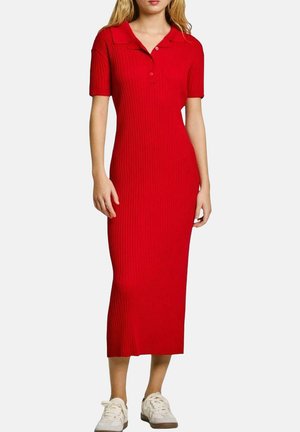 Vestido midi rojo acanalado con cuello tipo polo, mangas cortas y silueta ajustada, combinado con zapatillas blancas.