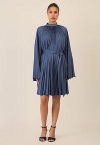 Blaues plissiertes Kleid mit langen Ärmeln, hohem Kragen und passendem Gürtel. Glatte Textur mit einem geschichteten Design, knielanger Saum und minimalistischen Akzenten.