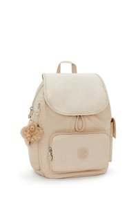 Zaino in tessuto beige con chiusura a patta, tasca frontale con zip, tasca laterale in rete e portachiavi a forma di scimmia in peluche staccabile. Design arrotondato e testurizzato.