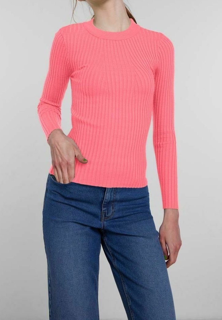 Figurbetontes, langärmliges Rippoberteil in leuchtendem Pink. Rundhalsausschnitt, strukturierter Stoff, kombiniert mit hochgeschnittenen blauen Jeans.