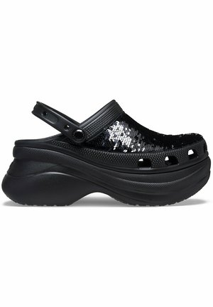 Sorte træsko med en kraftig platform, med en overdel i pailletter, justerbar rem og ventilationshuller langs siderne. Glat gummisål.