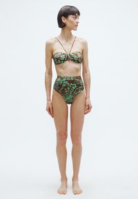 Bikini szett barna alappal és zöld absztrakt mintákkal, pánt nélküli felsővel és magas derekú alsóval, rugalmas anyagból készült.