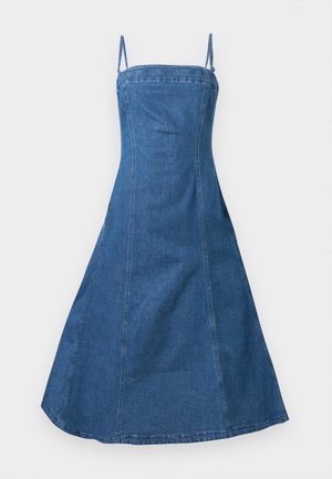 Μπλε denim midi φόρεμα με λεπτές τιράντες, εφαρμοστό μπούστο και φούστα που ανοίγει σε απλό ανοιχτό φόντο.