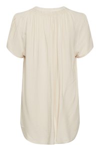 Blusa corta beige chiaro a maniche corte con sottile motivo a zigzag testurizzato e scollatura arricciata, mostrata da dietro.