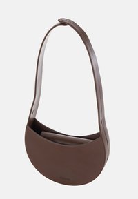 Brun, ovalt skuldertaske lavet af glat materiale, med en enkelt rem og et minimalistisk design. Logoet er brandet på fronten.