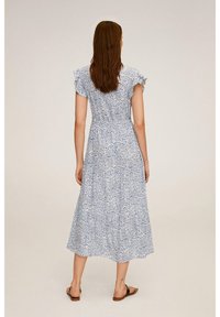 Blå og hvid blomster midi kjole med korte bølgede ærmer, tætsiddende talje og en svævende skirt. Blødt stof med en delikat mønster.