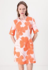 Rochie cu mânecă scurtă dintr-un material roz deschis, decorată cu modele mari florale de culoare portocalie, cu un guler rotund și o croială lejeră, având buzunare pe laterale.