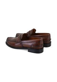 Bruine leren loafers met een gladde textuur, ronde neus en decoratieve stiksels. Voorzien van een lage zwarte rubberen hak en dubbele zijplooien.