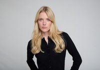 Cardigan nero con bottoni, a trama costellata, con colletto classico e maniche lunghe; modello con capelli biondi lunghi ed espressione neutra.