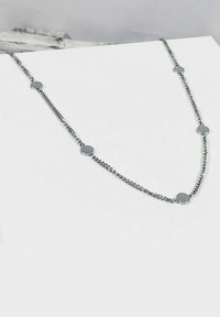 Collar de cadena de plata que presenta acentos metálicos redondos espaciados a lo largo de la cadena, con una textura suave y un diseño minimalista.