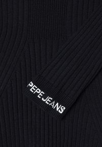 Crna rebrasta majica sa teksturiranim dizajnom. Sadrži bijeli logo "PEPEJEANS" na manžetama. Prikaz blizu detalja rukava.