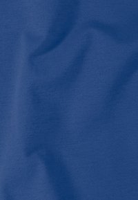 Gros plan sur un tissu bleu froissé avec une texture douce et lisse et un motif de tissage fin visible.