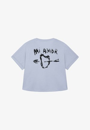 T-shirt bleu clair à manches courtes. Doté d'un design graphique noir d'un cœur et de flèches avec le texte "Mi Amor" au dos.