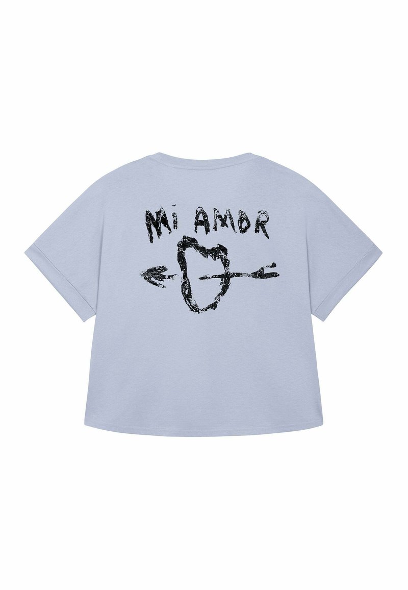 Lichtblauw t-shirt met korte mouwen. Voorkant heeft een zwart grafisch ontwerp van een hart en pijlen met de tekst "Mi Amor" op de achterkant.