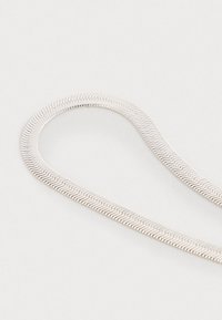 Zilveren slang halsketting, flexibele ontwerp met een gladde, ronde textuur en zigzagpatroon, weerkaatsend licht, zonder zichtbare sluiting.