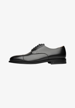 Zwarte leren oxford schoen met een gladde afwerking, ronde neus en een vetersluiting met vijf oogjes. Bevat subtiele stiknaden en een platte zool.