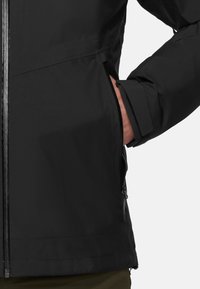 Giacca nera con finitura testurizzata, dotata di tasca con zip, polsini regolabili e design con collo alto. Aspetto liscio e slanciato.