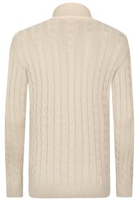 Suéter crema de punto trenzado con cuello alto, mangas largas, diseño texturizado y puños y dobladillo acanalados. Tejido de punto suave.