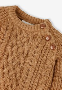 Strickpullover in einem warmen Beigeton mit strukturierten Zopfmustern, ausgestattet mit einem runden, gerippten Ausschnitt und zwei dekorativen braunen Knöpfen.