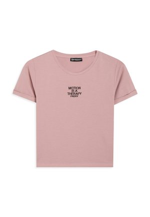 Maglietta di cotone rosa con maniche corte e scollo rotondo. Presenta un ricamo nero con la scritta "MOTION IS A THERAPY" al centro del petto.