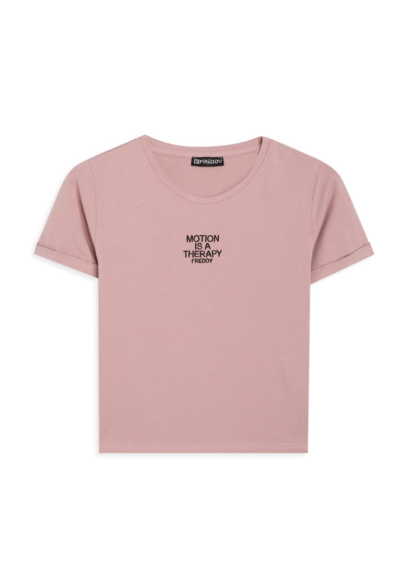 Camiseta de algodón rosa con mangas cortas y cuello redondo. Presenta un bordado negro con la frase "EL MOVIMIENTO ES UNA TERAPIA" centrada en el pecho.