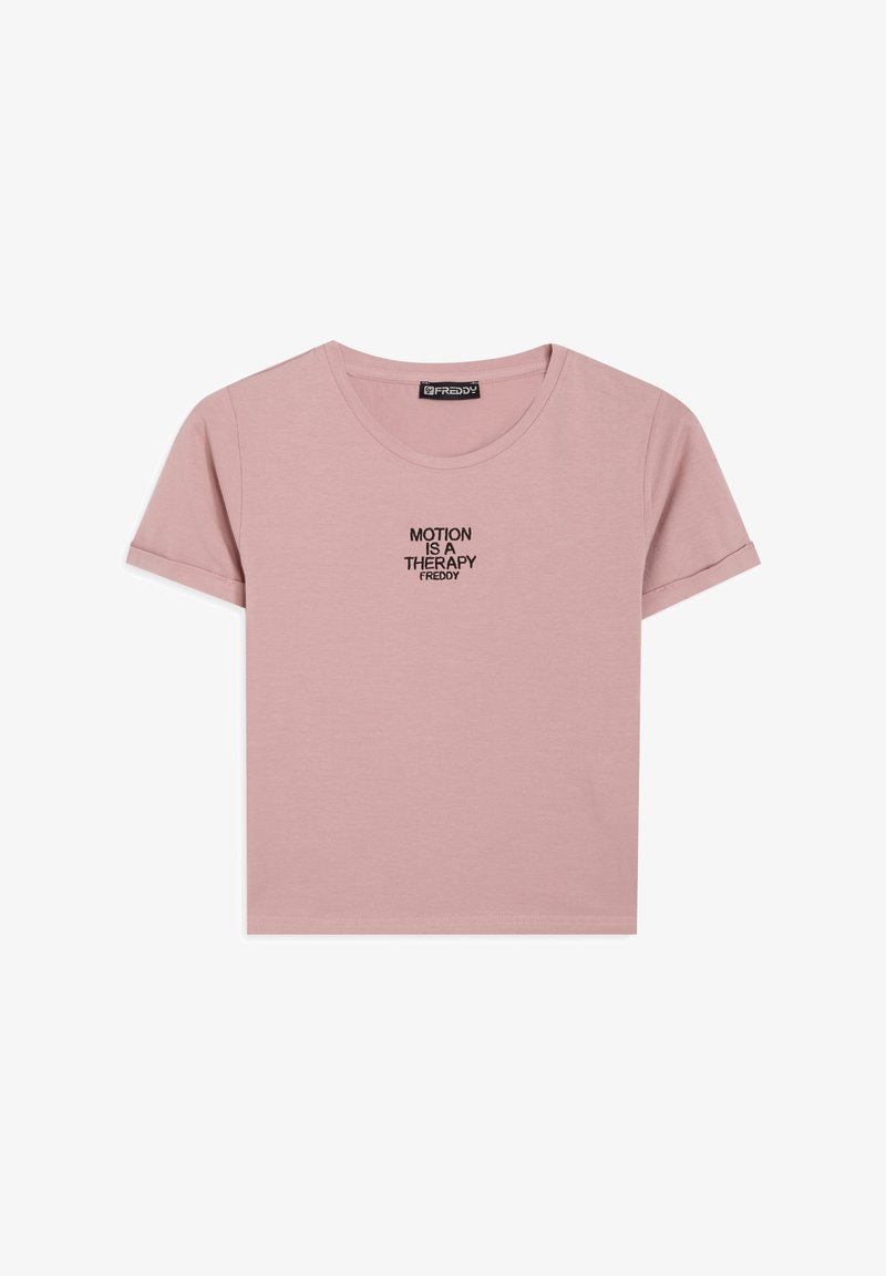 Camiseta de algodón rosa con mangas cortas y cuello redondo. Presenta un bordado negro con la frase "EL MOVIMIENTO ES UNA TERAPIA" centrada en el pecho.