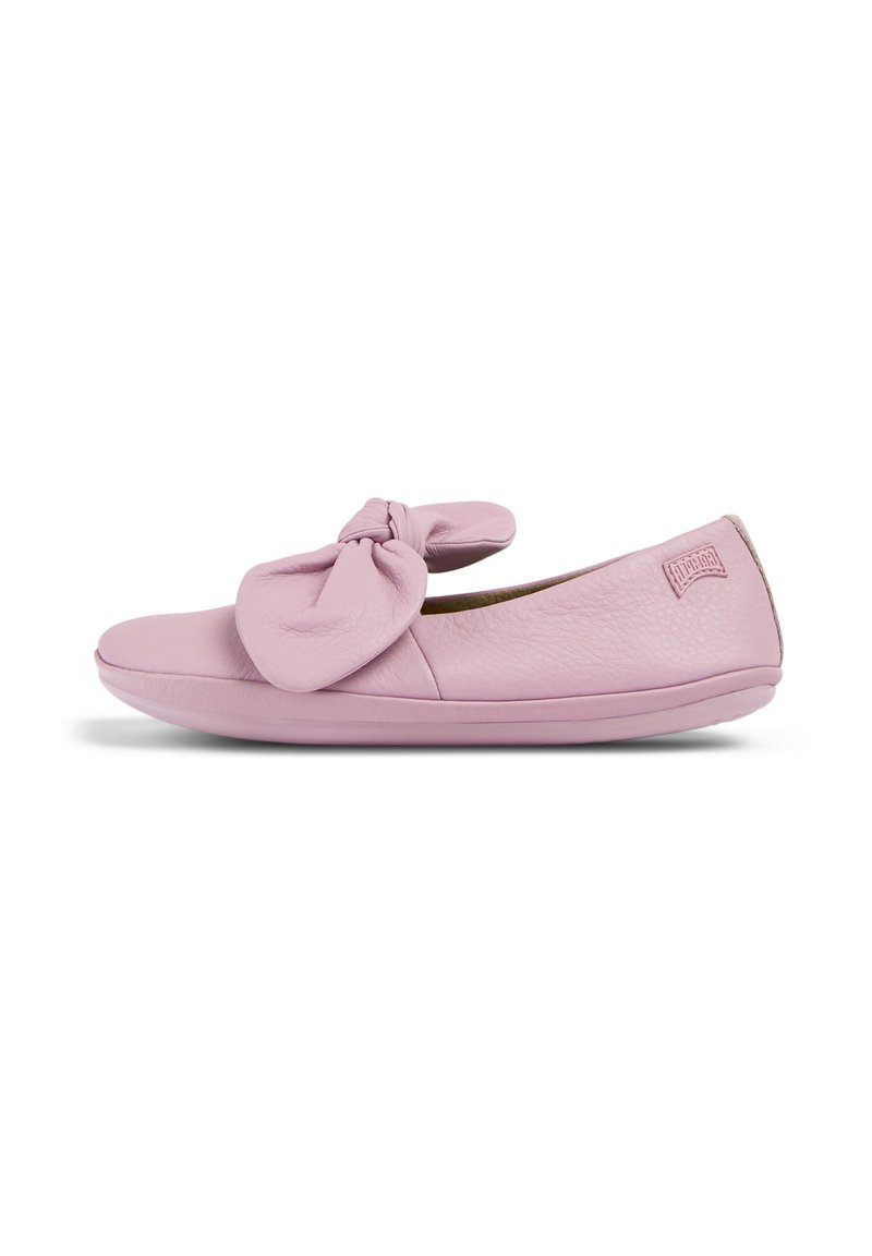 Bailarina de cuero rosa claro con un lazo anudado en la parte delantera y una puntera lisa y redondeada. Parte superior texturizada con un discreto detalle de logo en el talón.