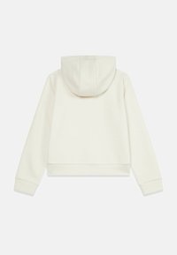 Sweat à capuche blanc court avec un motif texturé, doté d'une capuche à cordon, de poignets côtelés et d'un ourlet légèrement courbé.